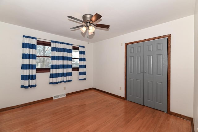 unfurnished bedroom with ceiling fan, hardwood / wood-style floors, and a closet