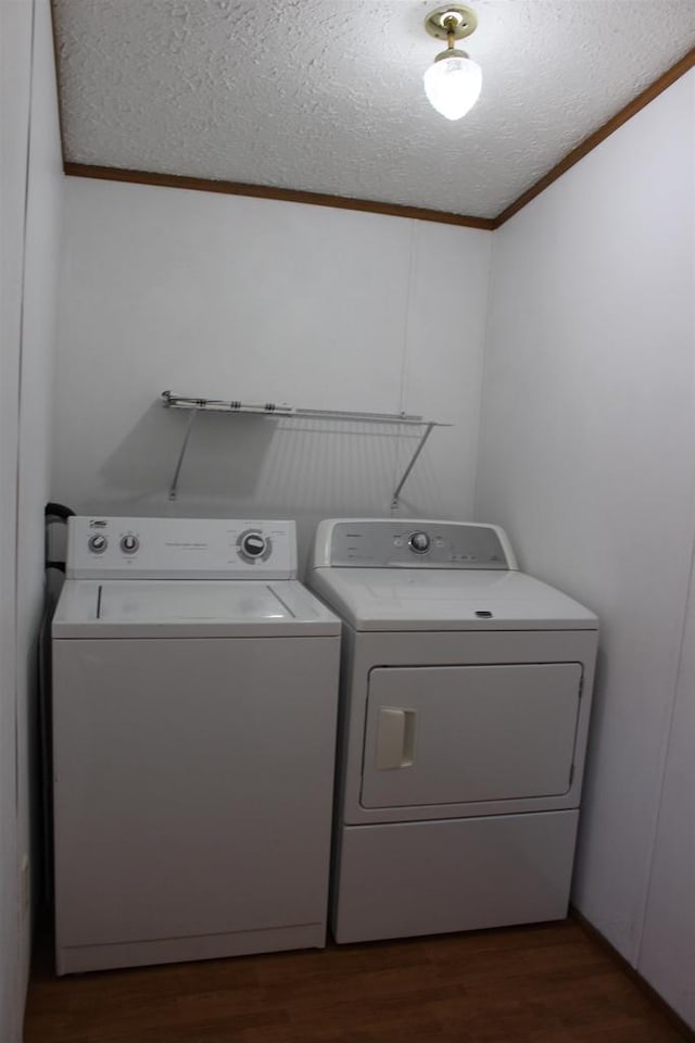 washroom with dark wood-type flooring, a textured ceiling, and independent washer and dryer