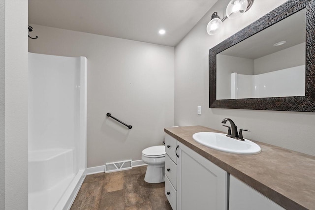 bathroom with vanity, walk in shower, and toilet