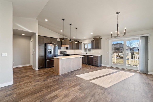 kitchen with appliances with stainless steel finishes, hanging light fixtures, dark hardwood / wood-style flooring, and a kitchen island