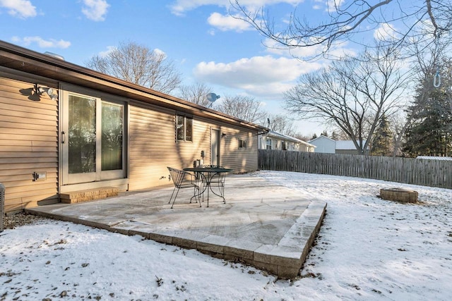 snow covered patio with a fire pit