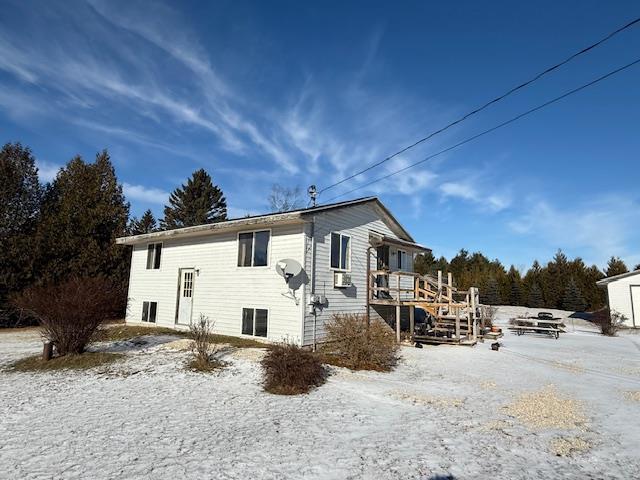 snow covered property with a wooden deck