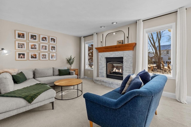 living room with a fireplace, light colored carpet, and plenty of natural light