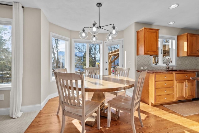 dining area with sink, a chandelier, and light hardwood / wood-style floors