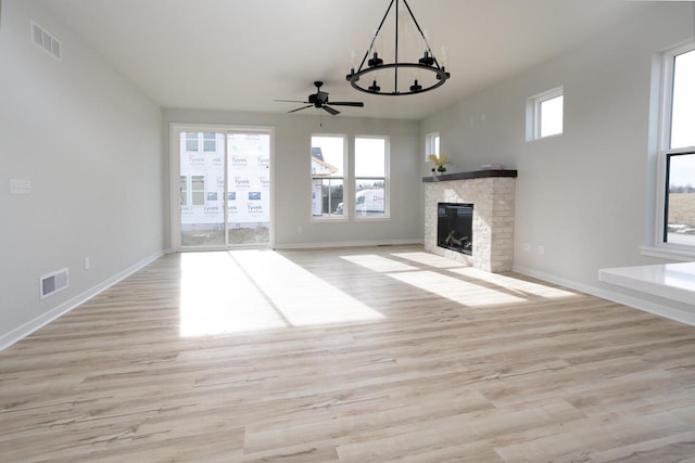 unfurnished living room with a fireplace, a healthy amount of sunlight, and light wood-type flooring