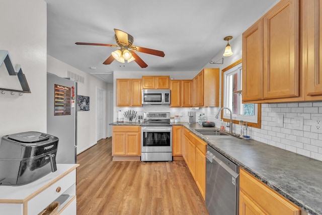 kitchen with sink, decorative backsplash, ceiling fan, and appliances with stainless steel finishes