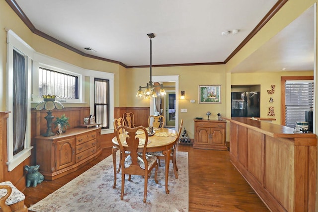 dining area with ornamental molding, dark hardwood / wood-style floors, and a chandelier