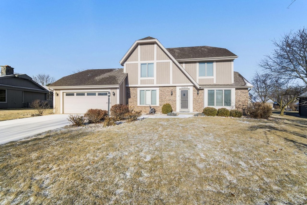 tudor home featuring a front yard and a garage