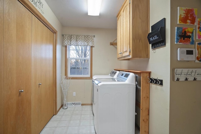 laundry area with independent washer and dryer and cabinets