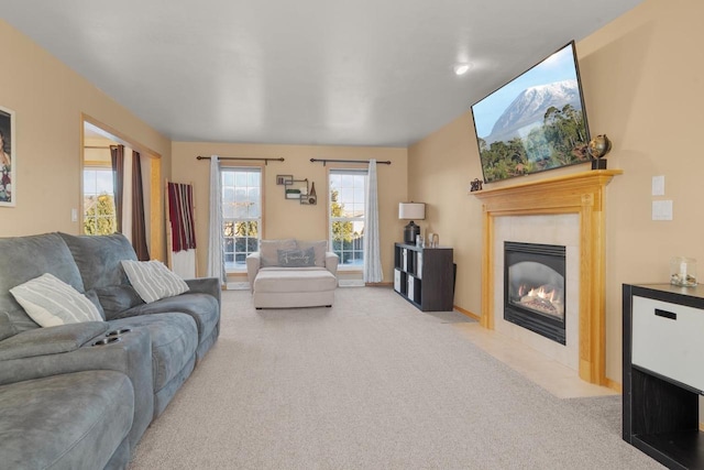 carpeted living room featuring a tiled fireplace