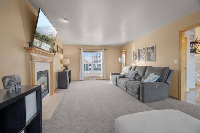 living room with a tiled fireplace and light carpet