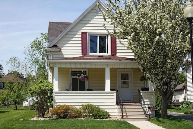 view of front of house with covered porch and a front lawn