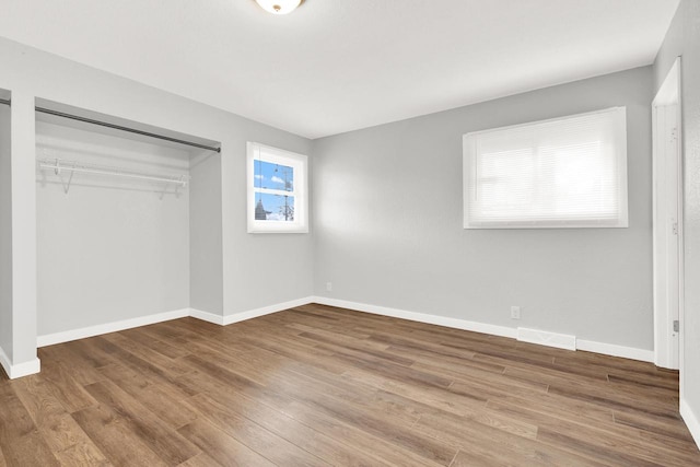 unfurnished bedroom featuring wood-type flooring and a closet