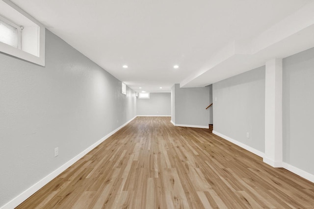 basement featuring a wealth of natural light and light hardwood / wood-style floors