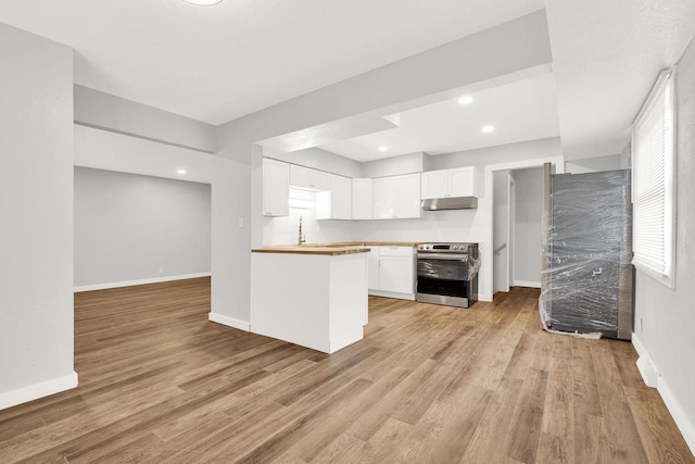 kitchen with light hardwood / wood-style floors, white cabinetry, stainless steel range with electric stovetop, and butcher block counters