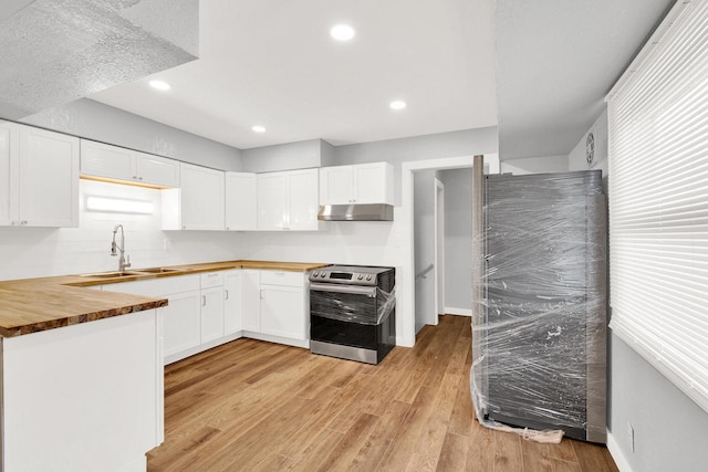 kitchen with sink, white cabinetry, light wood-type flooring, wooden counters, and electric range