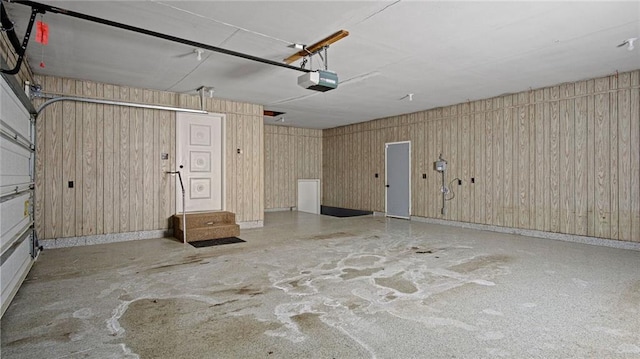 garage with a garage door opener and wooden walls