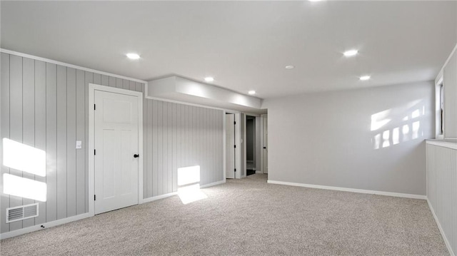 carpeted empty room with wooden walls