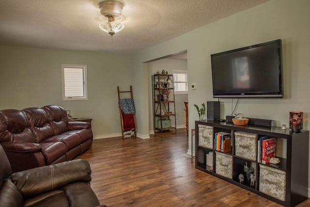 living room featuring a textured ceiling and dark hardwood / wood-style floors