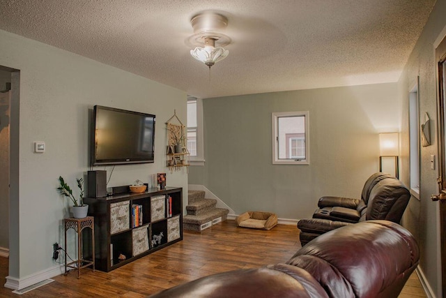 living room featuring wood-type flooring and a textured ceiling