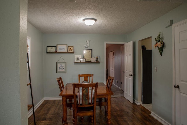 dining space with a textured ceiling and dark wood-type flooring