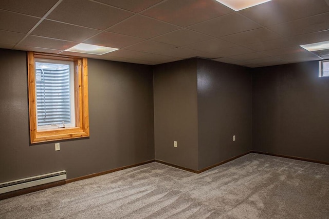 unfurnished room featuring a wealth of natural light, a paneled ceiling, a baseboard radiator, and carpet flooring