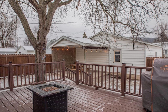 wooden deck with grilling area and a fire pit