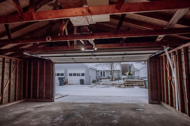 snow covered garage featuring a garage door opener