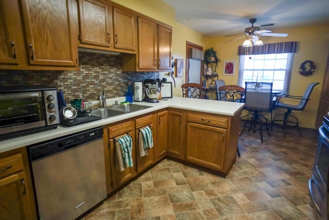 kitchen featuring kitchen peninsula, dishwasher, backsplash, ceiling fan, and sink