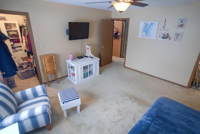 living area with light colored carpet and ceiling fan