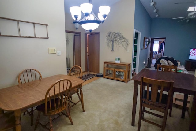 dining area with lofted ceiling, rail lighting, light carpet, and ceiling fan with notable chandelier