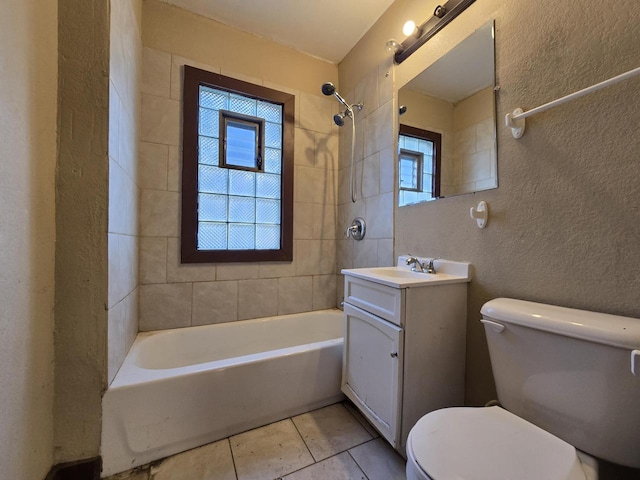 full bathroom with toilet, vanity, tile patterned floors, and tiled shower / bath