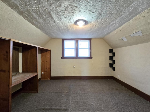 bonus room with a textured ceiling and vaulted ceiling