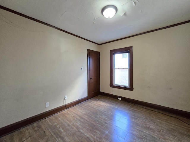 spare room featuring ornamental molding and dark hardwood / wood-style floors