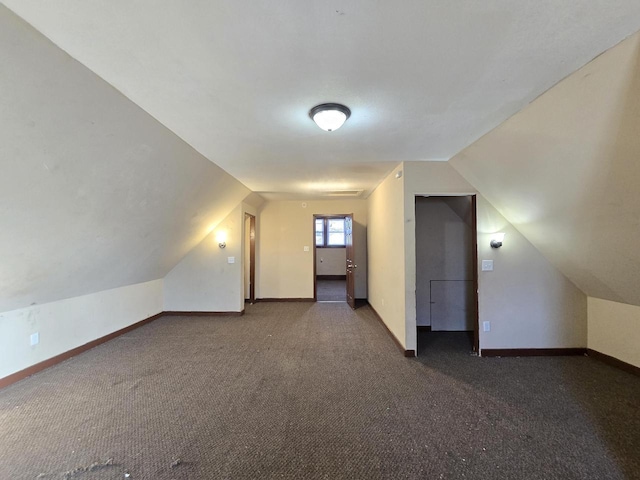 bonus room featuring dark colored carpet and vaulted ceiling