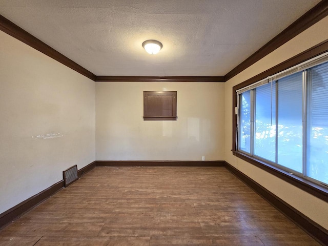 empty room featuring a textured ceiling, crown molding, and hardwood / wood-style floors