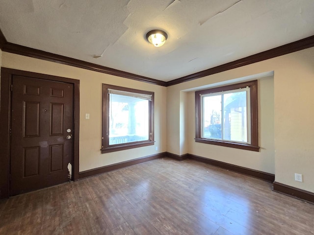 entrance foyer featuring hardwood / wood-style flooring, ornamental molding, and a wealth of natural light