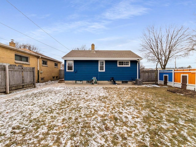 snow covered rear of property with a shed