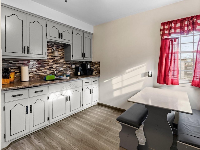 kitchen featuring sink, light hardwood / wood-style floors, backsplash, and gray cabinets