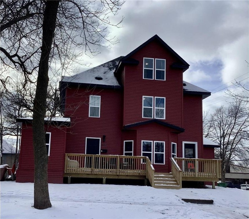 snow covered house with a wooden deck