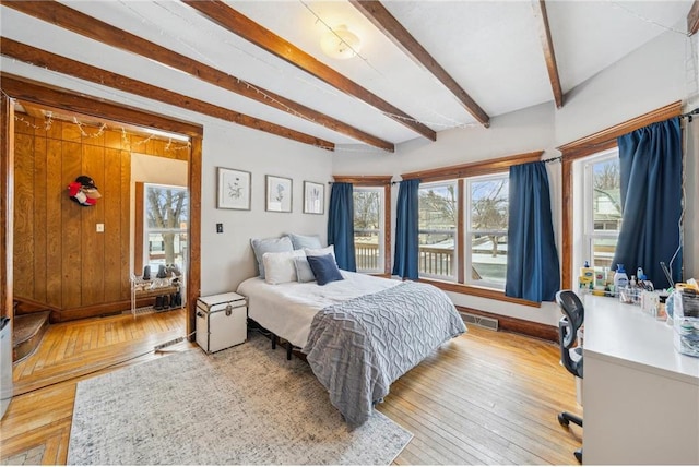 bedroom with beam ceiling and light hardwood / wood-style floors