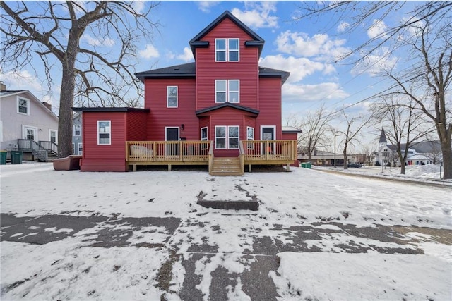 snow covered house with a wooden deck