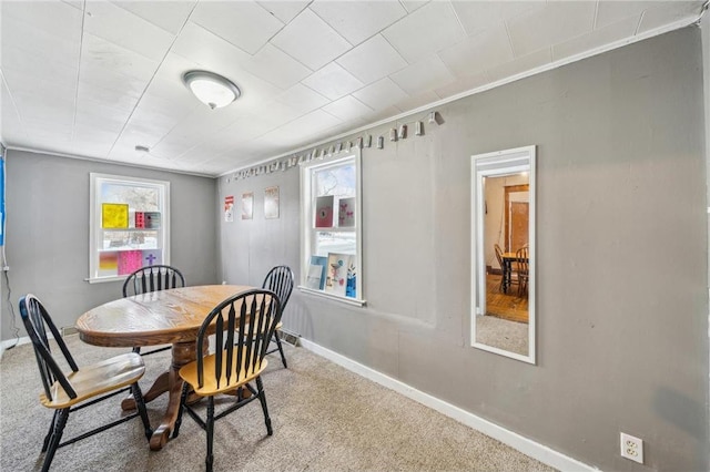 dining area featuring carpet, plenty of natural light, and ornamental molding