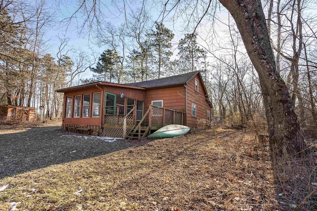 exterior space featuring a wooden deck and a sunroom