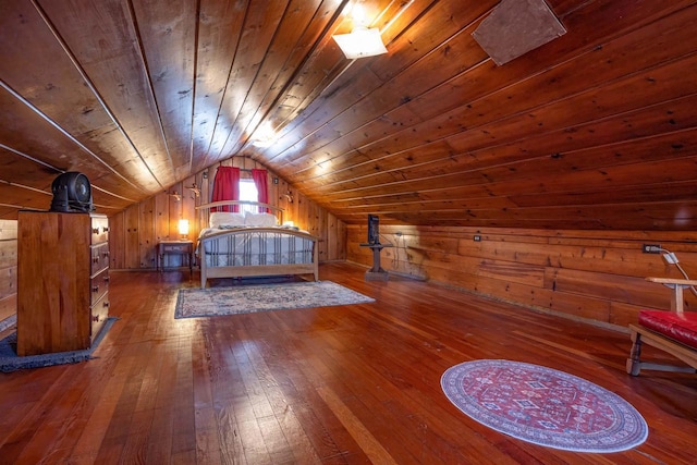 unfurnished bedroom with hardwood / wood-style flooring, wood walls, vaulted ceiling, and wood ceiling