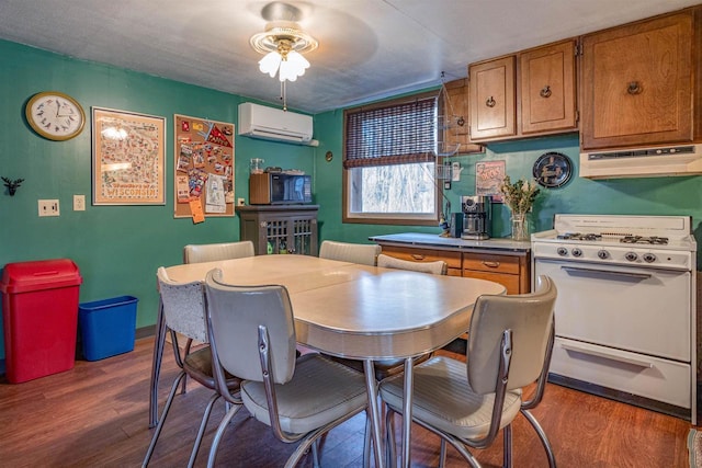 dining area featuring ceiling fan, a wall mounted air conditioner, and dark hardwood / wood-style flooring