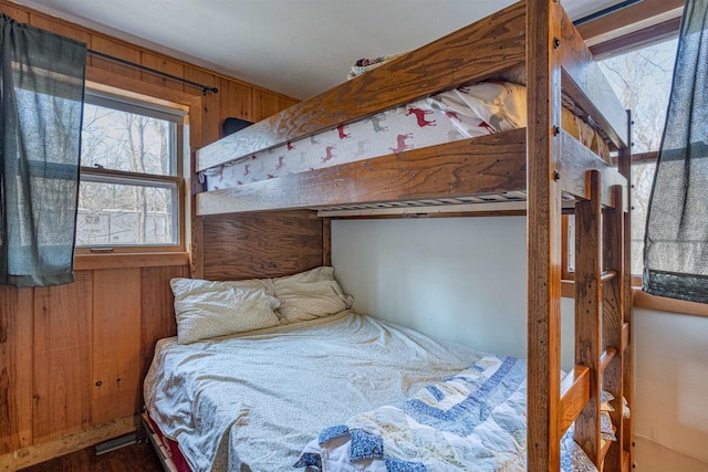 bedroom with wood walls and hardwood / wood-style floors