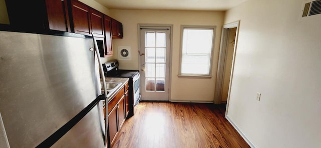 kitchen with stainless steel appliances and hardwood / wood-style floors