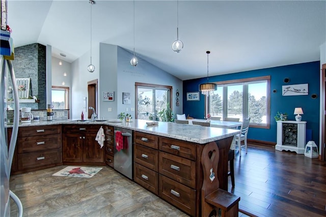 kitchen featuring a breakfast bar area, light stone counters, dishwasher, and pendant lighting