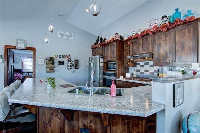 kitchen featuring stainless steel appliances, decorative light fixtures, vaulted ceiling, backsplash, and dark brown cabinets